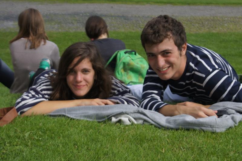 Chico y chica acostados en el césped sonriendo en el curso ingles irlanda
