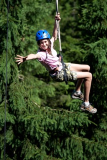 niña disfrutando de la tirolina en medio de la naturaleza en el campamento de verano en holanda