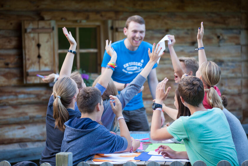 Grupo de participantes del campamento de verano Austria jugando a juegos con uno de los monitores
