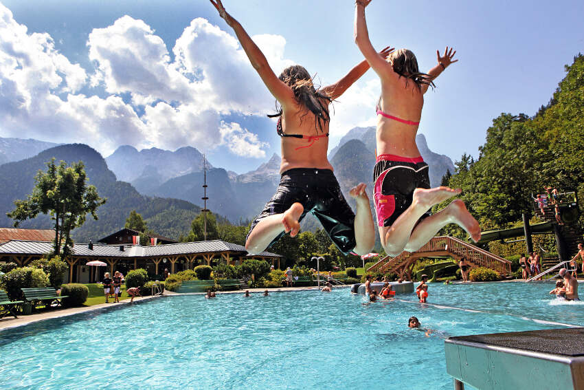 Jovenes saltando en la piscina del campamento de verano en holanda