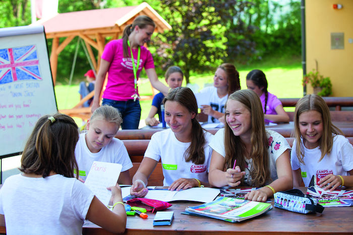 Jovenes haciendo los deberes en las clases de idiomas del campamento de verano en el extranjero