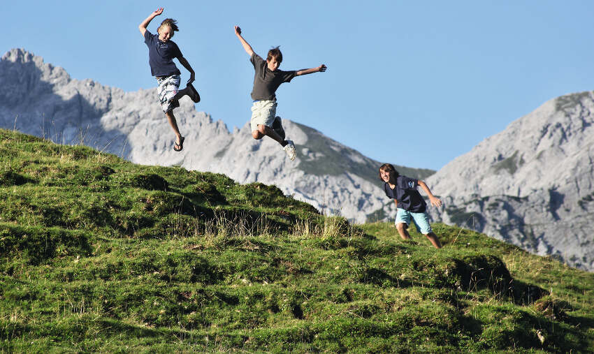 Grupo de jovenes corriendo y saltando por la naturaleza del campamento de verano en holanda