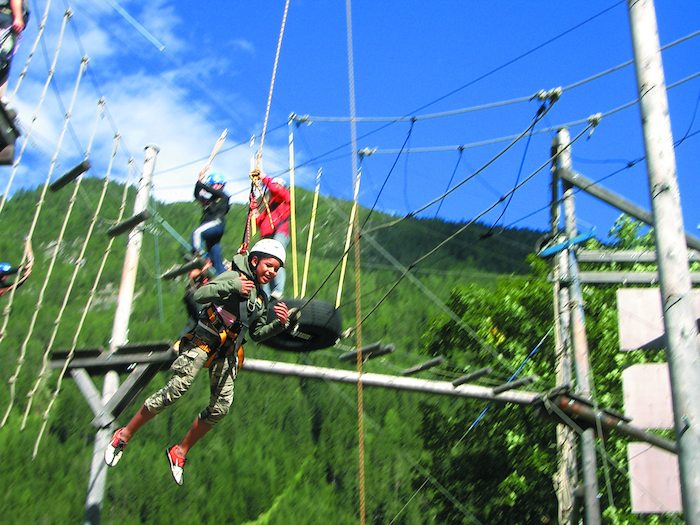Joven lanzandose en el parque multiaventura del campamento de verano en holanda