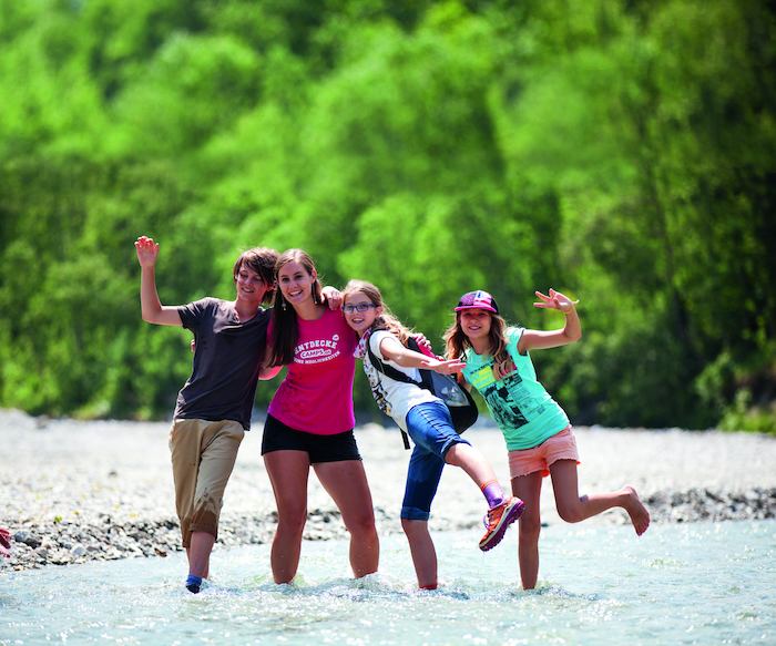 Grupo de jovenes caminando por la naturaleza del campamento de verano en holanda