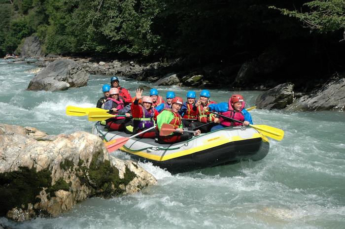 Grupo de jovenes haciendo kayak por el lago del campamento de verano en holanda
