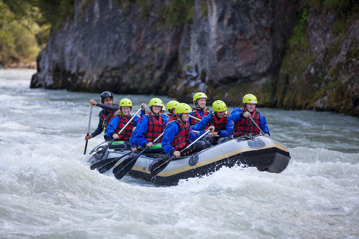 Jovenes haciendo rafting en grupo en el campamento de verano en holanda