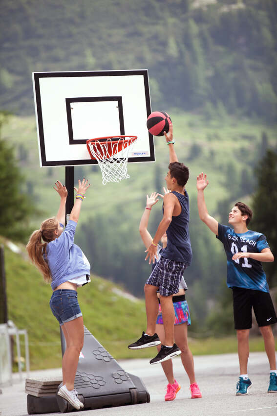 Grupo de jovenes jugando un partido de baloncesto en el campamento deportivo en holanda