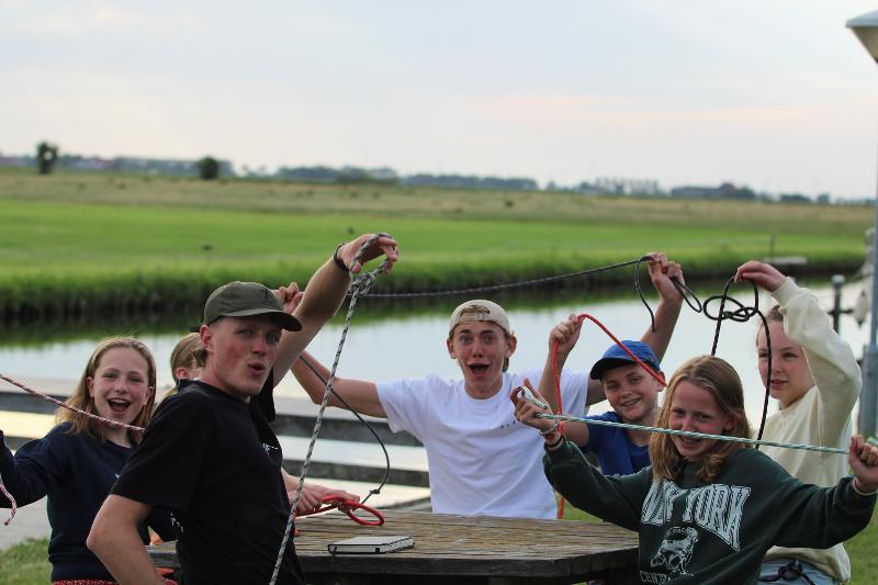 Jóvenes aprendiendo a hacer nudos en el campamento de verano en Holanda
