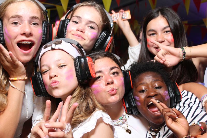 Chicas posando con auriculares y la cara pintada en el campamento de verano en Holanda