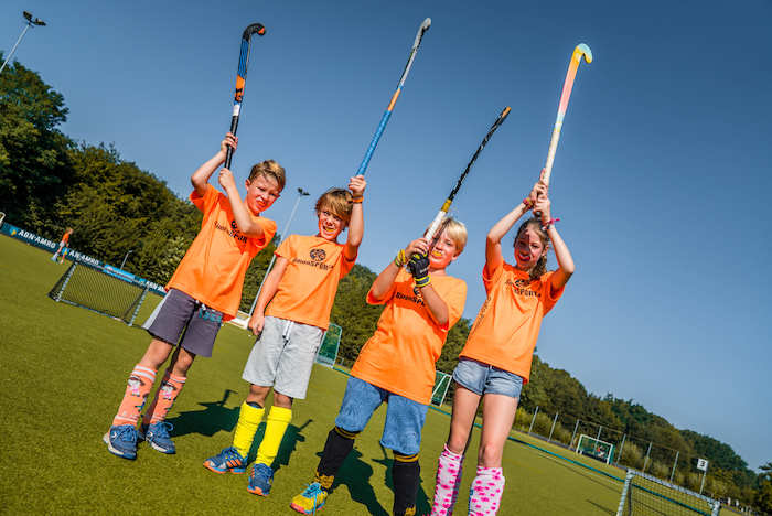 grupo de jovenes practicando hockey en las actividades deportivas del campamento de verano en holanda