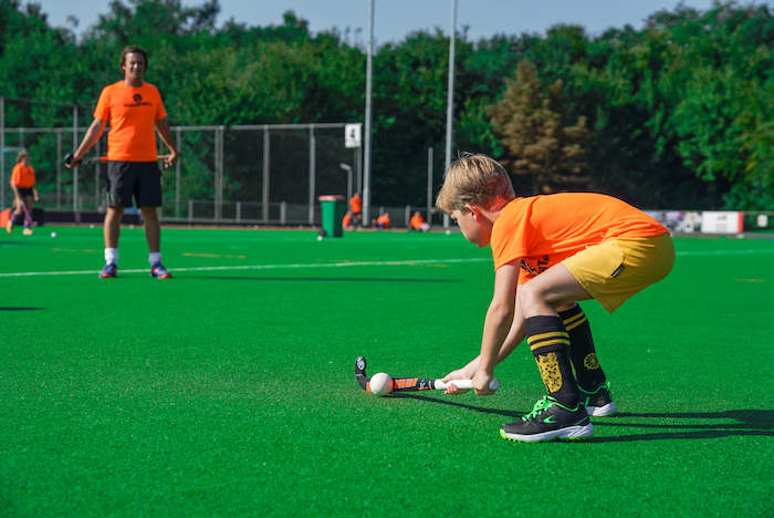 niño haciendo deporte en el hockey durante el campamento de verano en Holanda