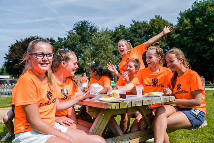 grupo de chicas comiendo en la naturaleza del campamento de verano en holanda