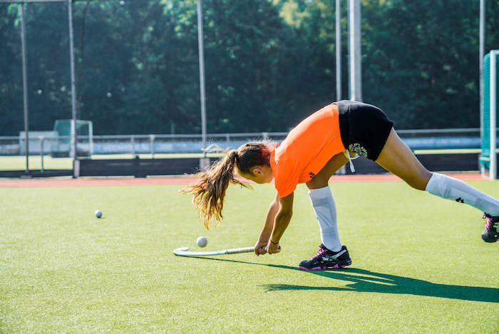 niña hace deporte practicando hockey en el campamento de verano en holanda