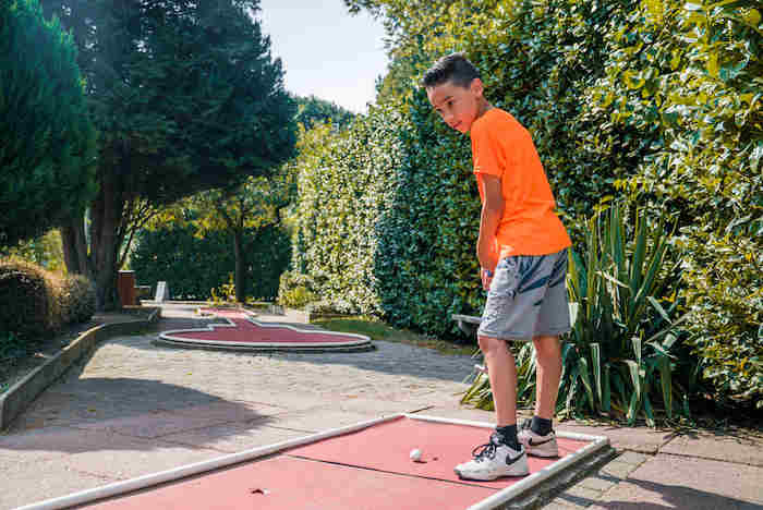 niño jugando al golf en el campamento de verano en holanda