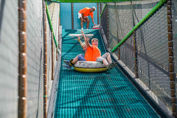 niños deslizandose por el tobocan con los juegos del campamento de verano en holanda