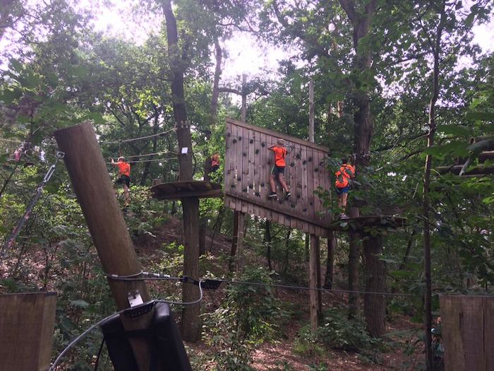 jovenes realizando escalada en la naturaleza del campamento de verano en holanda