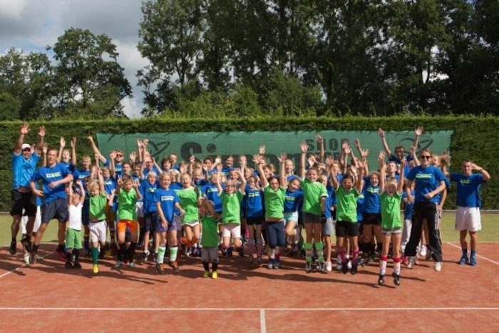 grupo de jovenes celebrando la victoria del partido de tenis en el campamento de verano en holanda