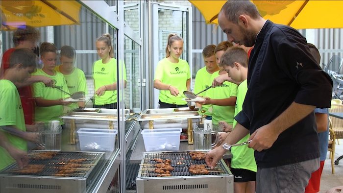 grupo de jovenes preparandose para comer en el campamento de verano en holanda