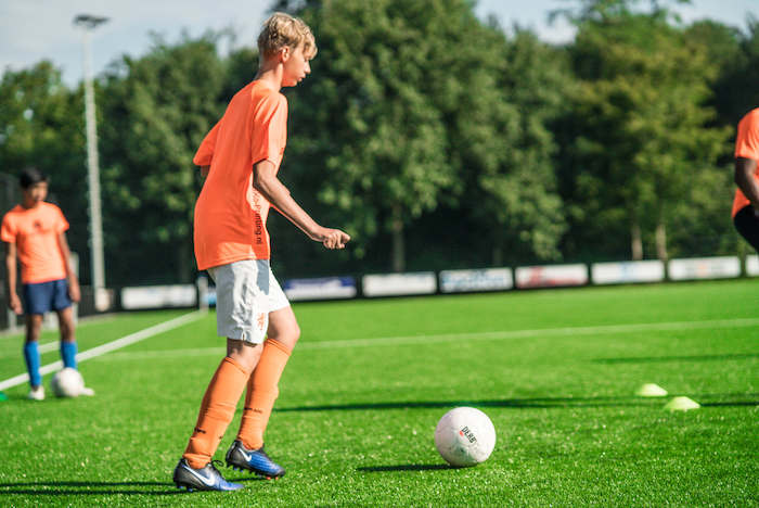 Joven a punto de lanzar el balon en un partido de futbol del campamento de verano en holanda