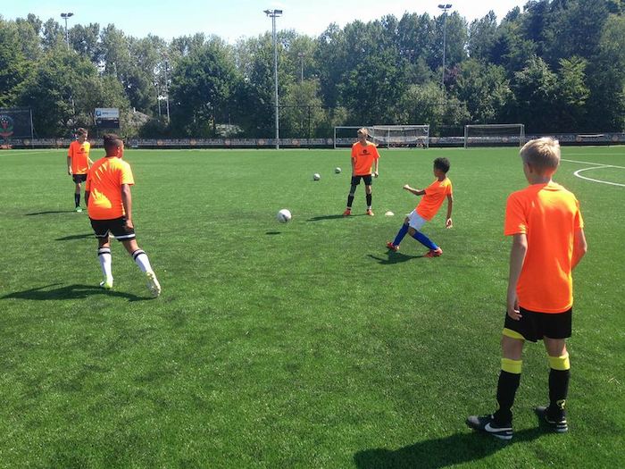 Jovenes disfrutando de un partido de futbol en el campamento de verano en holanda