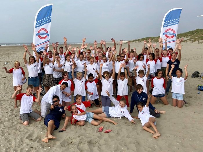 grupo de jovenes en la playa para las competiciones de actividades acuaticas del campamento de verano en holanda