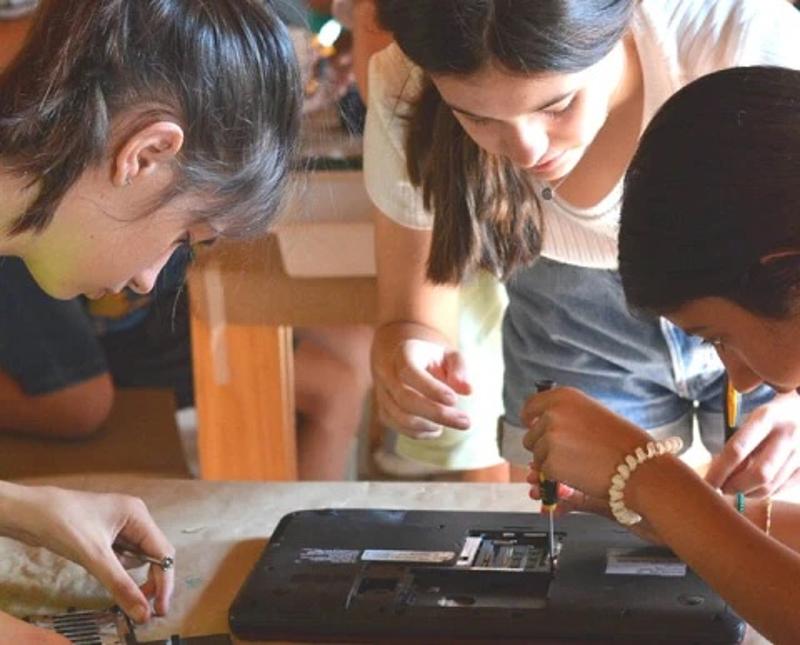 Niñas usando un destornillador en el campamento