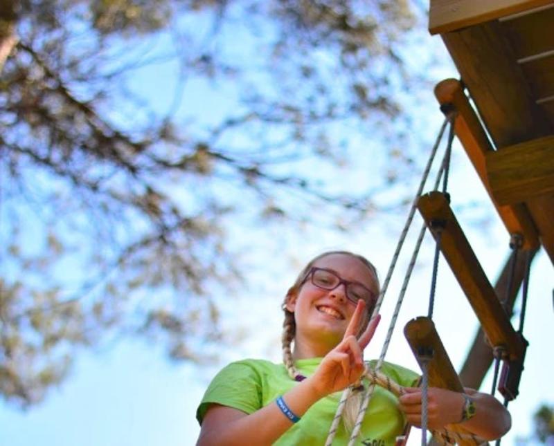 Chica posando en una escalera en el campamento