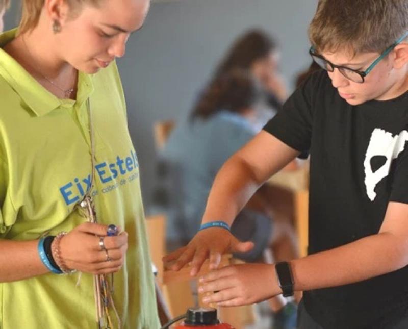 Chico y monitora haciendo un experimento en el campamento