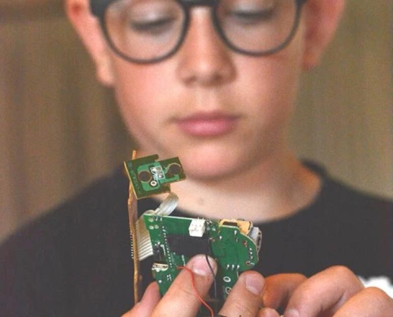 Niño manejando una placa electrónica en el campamento