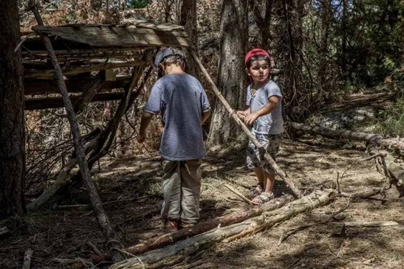 Foto de unos niños construyendo una cabaña en una colonia de verano en Francia en la naturaleza