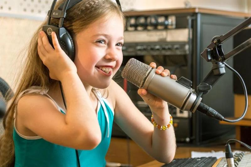 niña con un microfono preparada para una clase de musica en el campamento de verano en francia