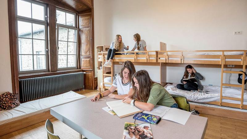 niñas estudiando los deberes de las clases de idiomas del campamento de verano en Alemania en su habitación