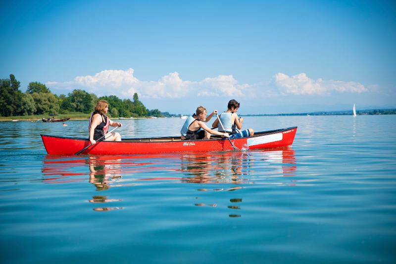 grupo de jovenes remando en el lago del campamento de verano en alemania