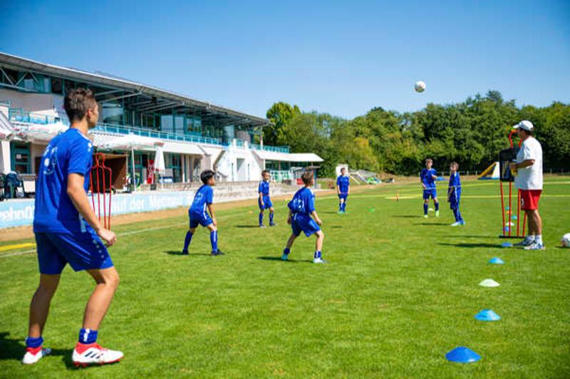 niños practicando tecnica de futbol durante su campamento de verano en alemania