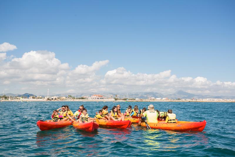 Chicos y chicas en kayaks en el mar el la colonia náutica en Valencia