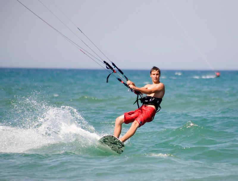 Chico haciendo kitesurf en el mar en la colonia náutica en Valencia