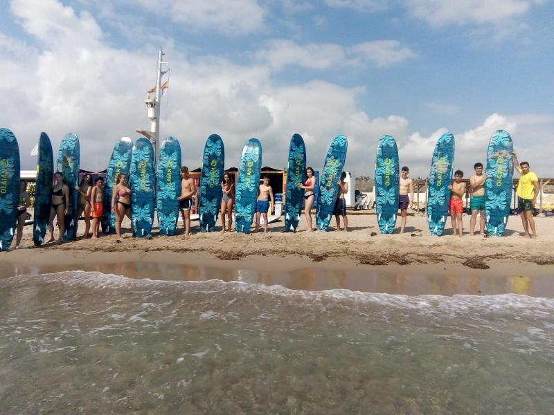 Campistas con su tabla de surf en la playa en colonia náutica en Valencia