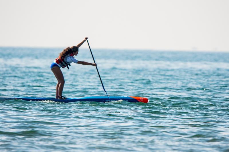 una joven haciendo paddle surf en un viaje fin de curso