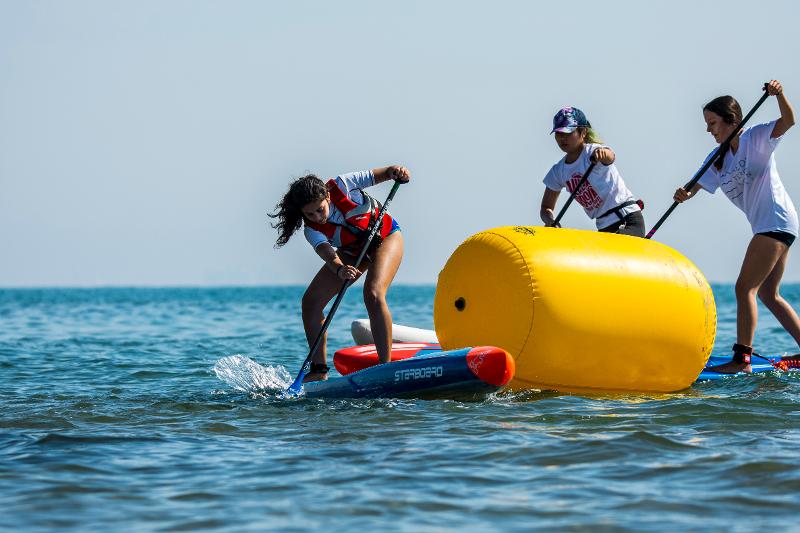 Chicas remando en el mar en colonia náutica en Valencia