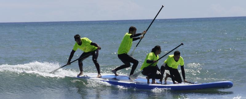 Cuatro campistas haciendo SUP en colonia náutica en Valencia