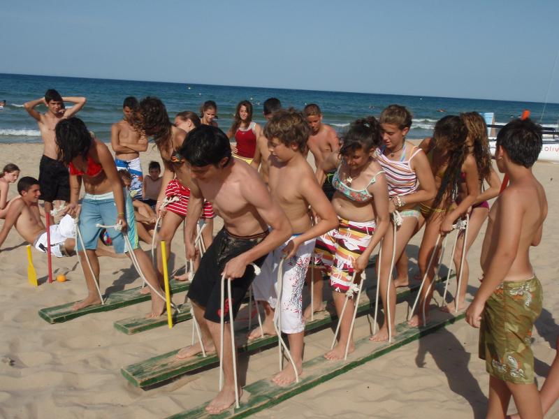 grupo de jovenes realizando juegos en la playa del campamento de verano en valencia