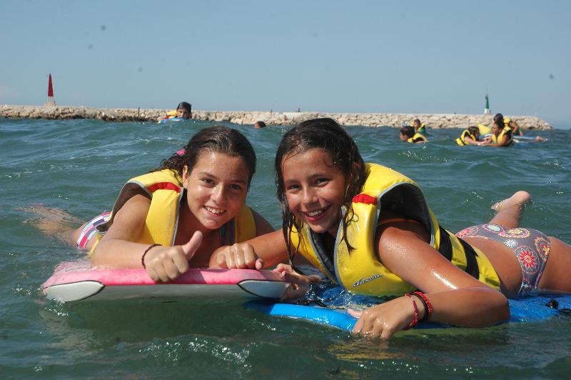 niñas practicando surf con bodyboard en la playa del campamento de verano Comunidad Valenciana