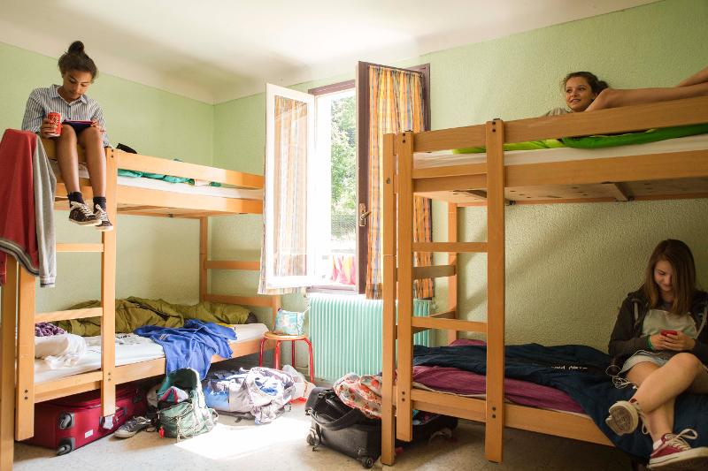 jovenes en la habitacion del campamento de verano en francia descansando para las siguientes actividades