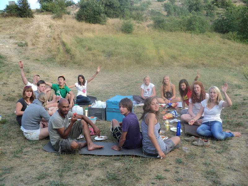Jovenes divertidos en un picnic en la naturaleza con los monitores del campamento de verano en francia