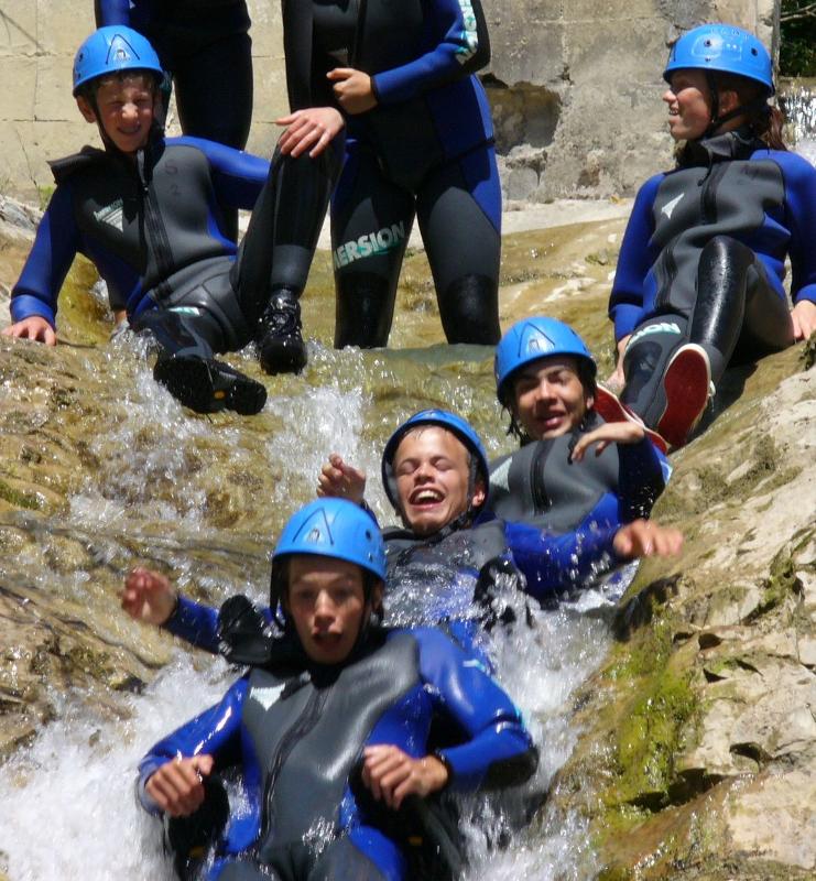 Grupo de niños realizando rafting en la naturaleza con el campamento de verano en francia
