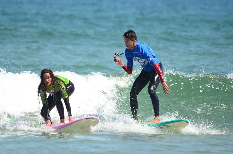 Niños practicando surf mientras se graban para el campamento de verano en Cantabria