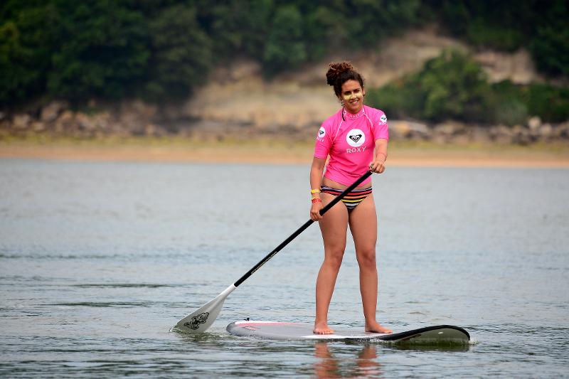 niña practicando paddle surf en el campamento de verano en Extremadura