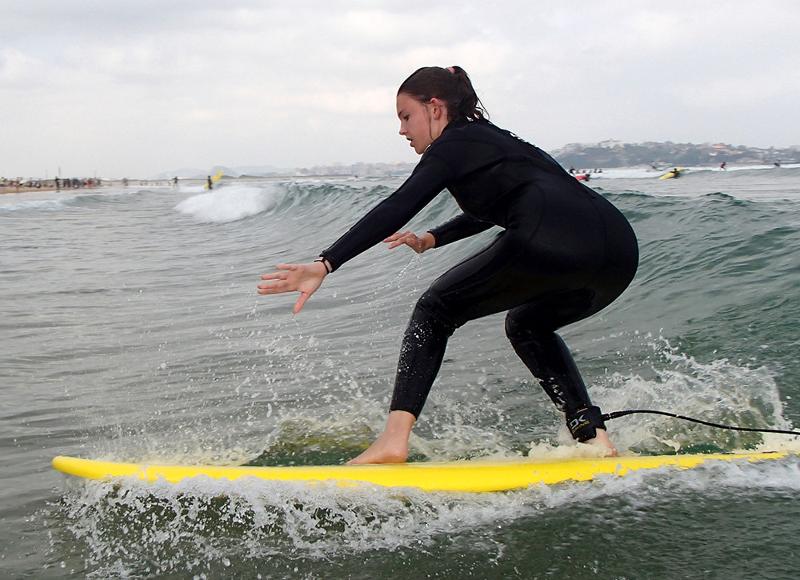 Chica surfeando concentrada en surfcamp en cantabria