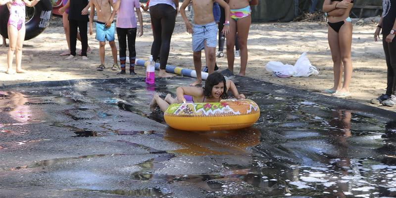 grupo de jovenes haciendo juegos acuaticos en las instalaciones del campamento de verano en portugal