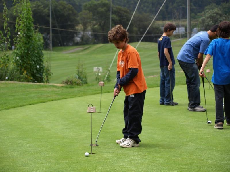 niño jugando al golf en el campamento de verano en portugal